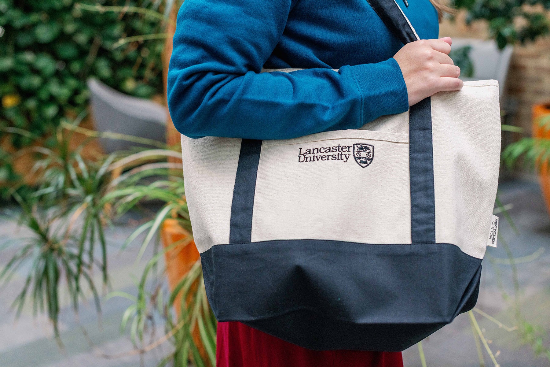 Person holding a Lancaster University tote bag outdoors